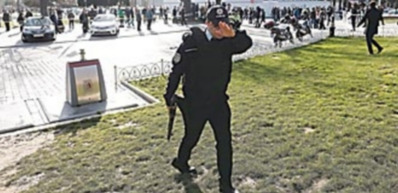 Un policía delimita el perímetro de seguridad mientras personal de emergencias trabajan en el escenario de la fuerte explosión producida junto a la Mezquita Azul. / EFE