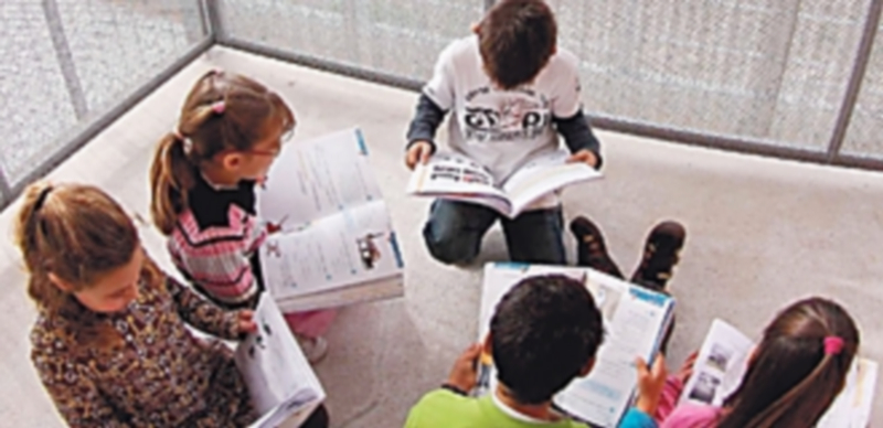 Varios niños consultan los libros de texto para cuya compra la Junta cuenta con una línea de ayudas. / Europa Press