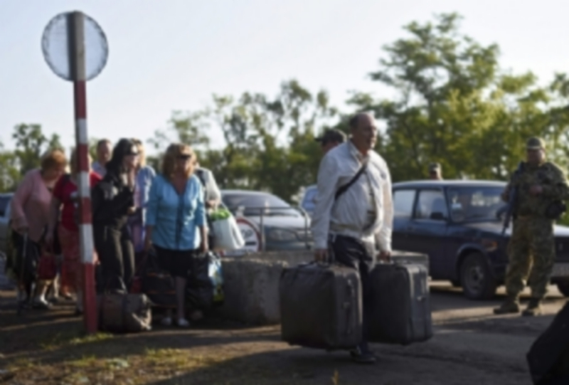 Varias personas cruzan el puesto de control de Zaytsevo en Ucrania. / EFE