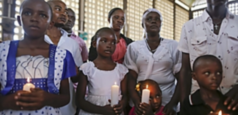 Cristianos keniatas sostienen velas durante la ceremonia en memoria de los estudiantes abatidos en el atentado. / EFE