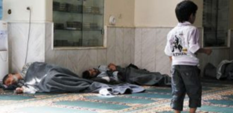 Un niño pasea junto a los cadáveres de algunos de los cientos de fallecidos en el ataque del pasado miércoles. / Reuters