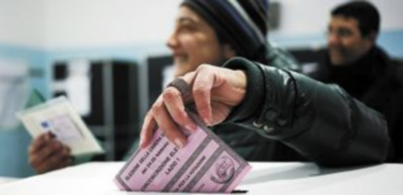 Un ciudadano introduce su voto en la urna de un colegio electoral en Roma. / Reuters
