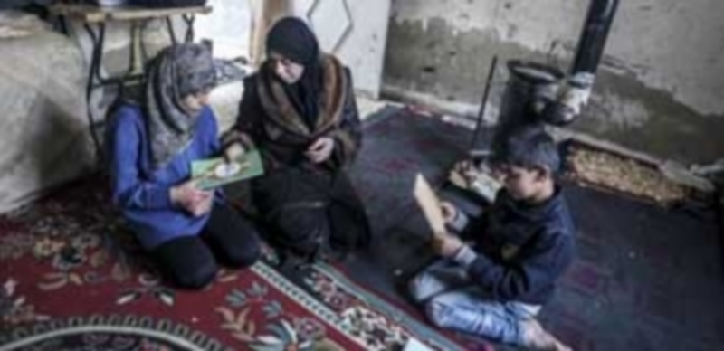 Una mujer ejerce de maestra con sus hijos en su casa del distrito de Al-Qaboon en la capital siria