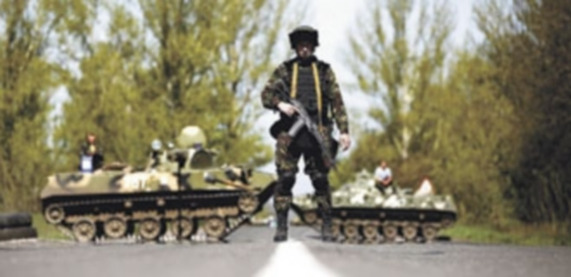 Un soldado ucraniano monta guardia delante de un punto de comprobación cerca del pueblo de Malinivka. / Reuters