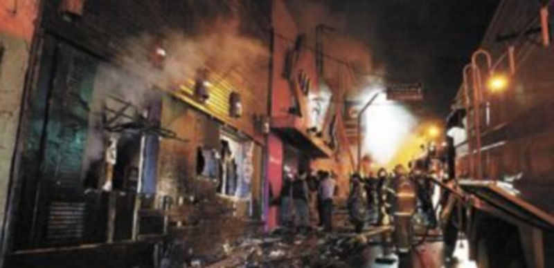 Los bomberos tuvieron que abrir varios agujeros en las paredes del local para poder acceder a las instalaciones. / Reuters