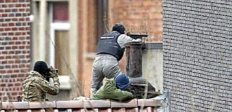 Agentes de seguridad toman posiciones durante la operación policial llevada a cabo en el barrio de Forest en Bruselas. / EFE