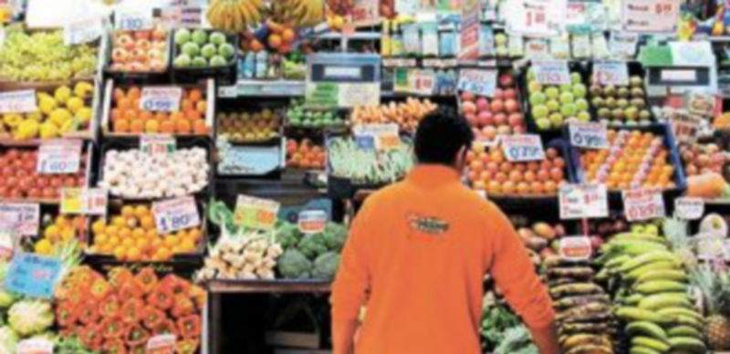 Un hombre coloca adecuadamente los productos de su establecimiento para que resulten atractivos a los clientes.