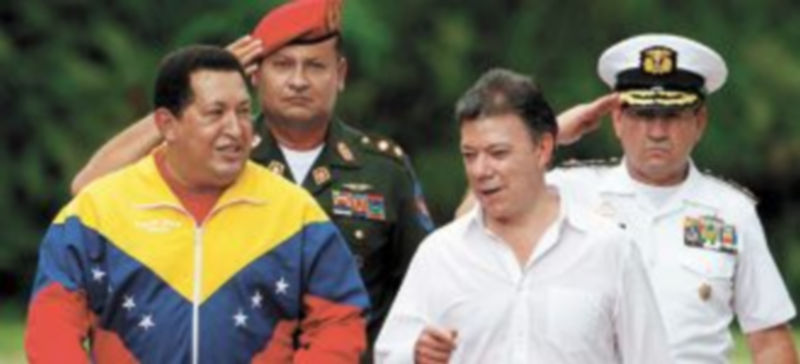 Hugo Chávez (i) y Juan Manuel Santos pasan juntos revista a una guardia de honor