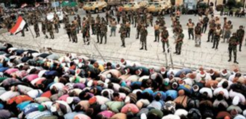 Seguidores de Mursi rezan delante de la sede de la Guardia Republicana y ante la presencia de numerosos soldados. / MOHAMMED SABER (EFE)