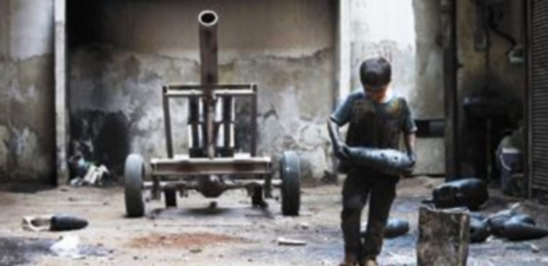 Un niño prepara un carro de combate y diversa munición para las fuerzas rebeldes en Alepo