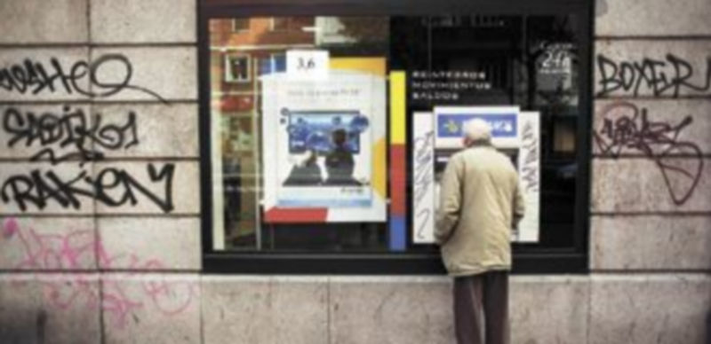 Un ciudadano espera a que el cajero automático de una empresa bancaria termine la operación solicitada. / Reuters