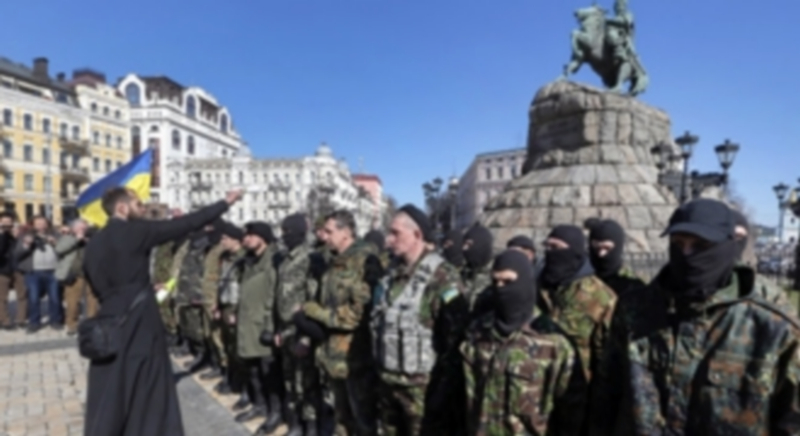 Un cura ortodoxo bendice en Kiev a varios voluntarios del batallón de la ONU antes de ser enviados al conflico en el este del país durante el día de ayer. / Efe