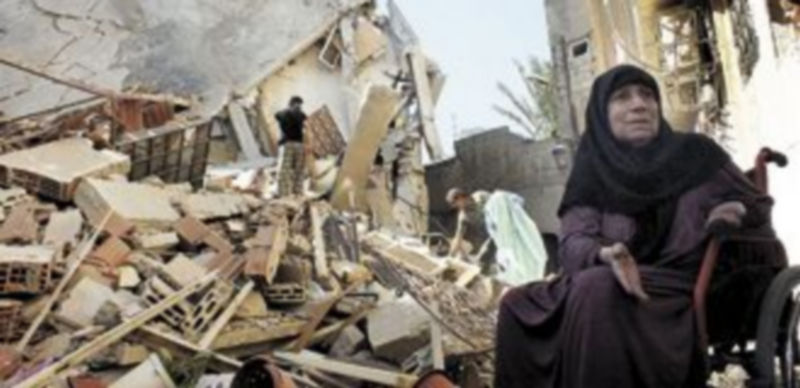 Una mujer observa uno de los edificios derruidos por los bombardeos sobre Damasco. / Reuters