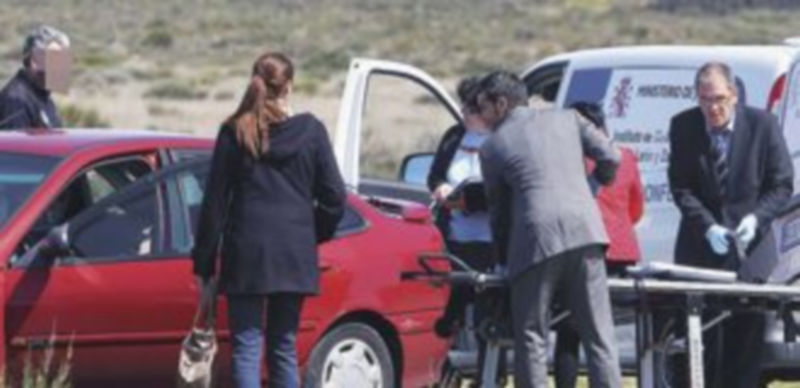 Miembros de la Policía buscan pruebas en uno de los vehículos donde apareció uno de los cadáveres. / Ical