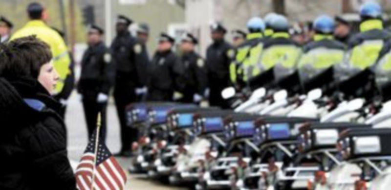 Un niño observa a los oficiales que acudieron al funeral de uno de los agentes muertos durante el tiroteo. / Efe