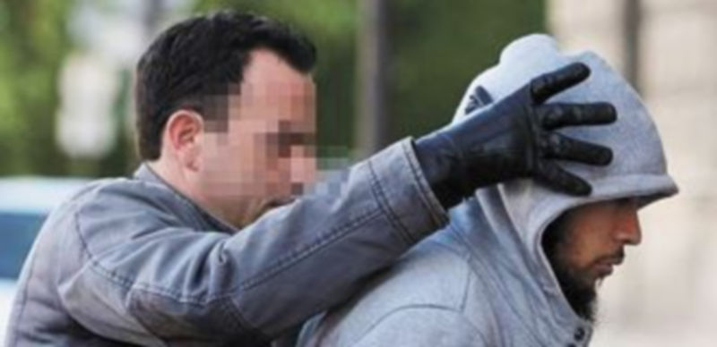 Un agente traslada a Alexandre a la Comisaría tras detenerle en la casa de un amigo