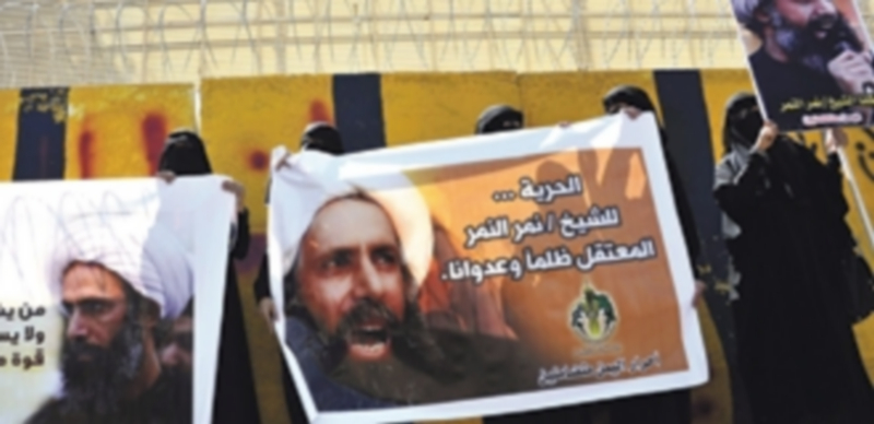 Varias mujeres reunidas para mostrar una fotografía del clérigo Al Nimr. / EFE