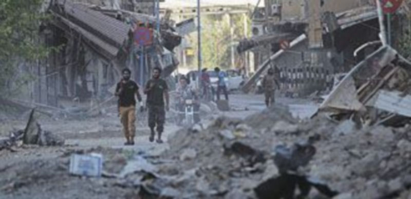 Un hombre reconoce el cuerpo sin vida de un niño entre la multitud de cadáveres depositados en una improvisada morgue. / Reuters