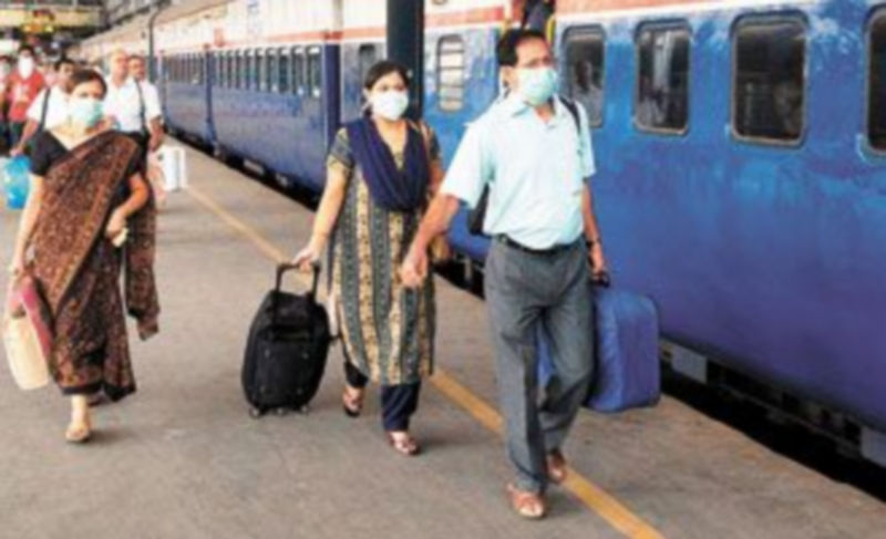 Pasajeros de un tren en La India utilizan mascarillas como medida de protección. / EFE