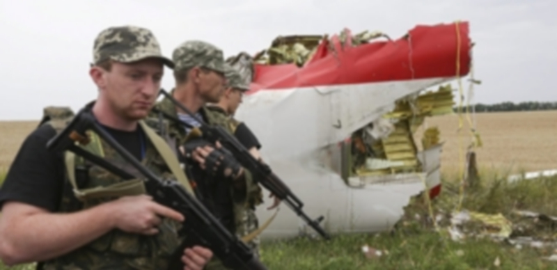 Rebeldes prorrusos armados permanecen apostados al lado de los restos de fuselaje del aparato malasio que cayó el jueves alcanzado por un misil en Ucrania. / Efe