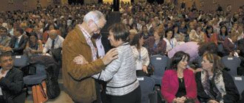La ministra Elena Espinosa saluda a uno de los asistentes a la celebración del Día de la Mujer Rural. A la derecha sentada