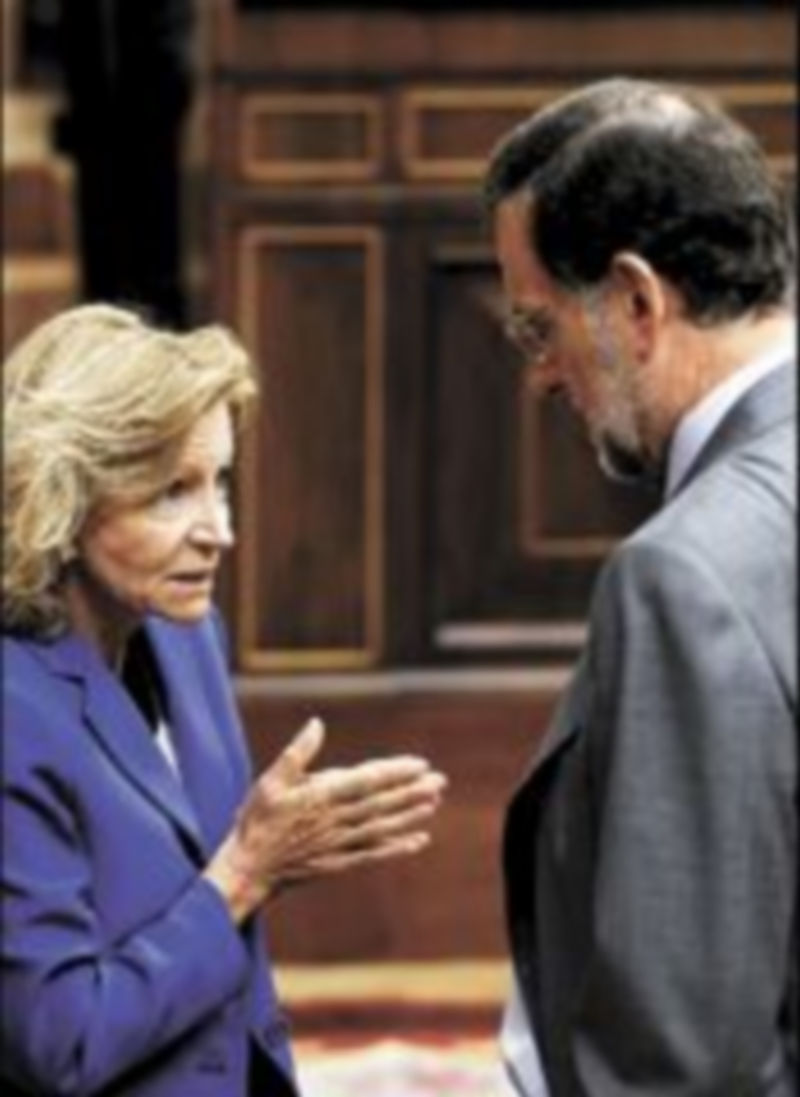 Salgado y Rajoy conversan en el hemiciclo durante la jornada de ayer. / Efe.