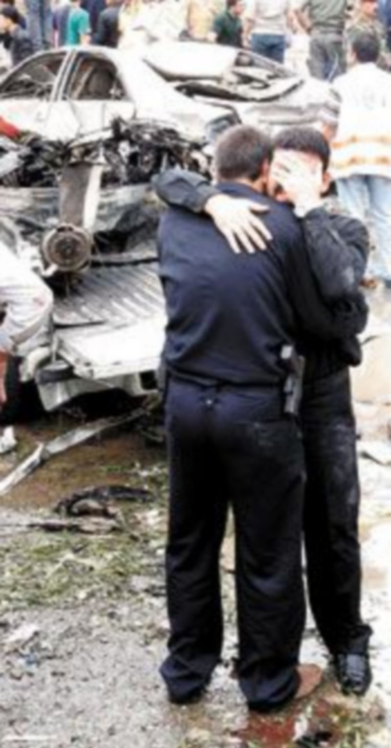 Dos policías se abrazan junto al lugar donde estallaron las bombas. / EFE