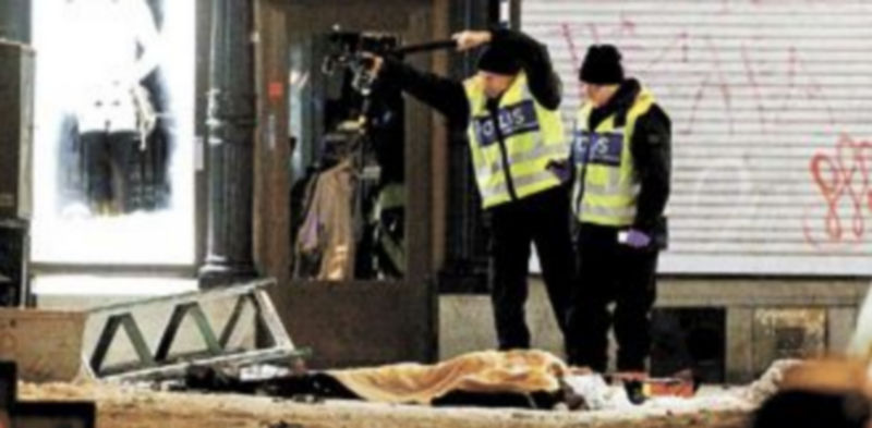 Un grupo de la Policía forense examina los restos del supuesto suicida que quedó tendido en una céntrica calle de Estocolmo. / Efe