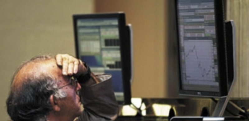 Un hombre sigue la información del panel en la Bolsa madrileña. / Reuters