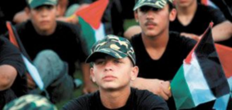 Jóvenes palestinos descansan durante un campamento de verano organizado por Hamas en un estadio de fútbol de la franja de Gaza. / Efe