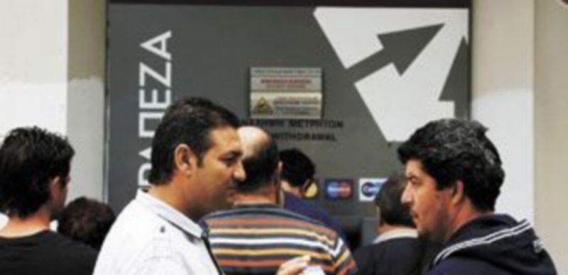 Los ciudadanos de la isla mediterránea hacen cola para retirar dinero en efectivo de un cajero automático. / Reuters