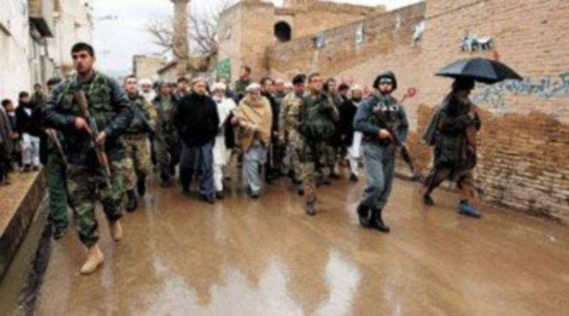 Soldados italianos de la ISAF escoltan a su comandante y a oficiales afganos durante la presentación de un proyecto para construir una carretera en Herat. / EFE