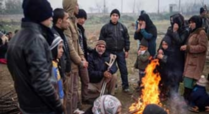 Un grupo de refugiados hace frente a las inclemencias del invierno europeo con una hoguera para no sufrir congelación. / Efe