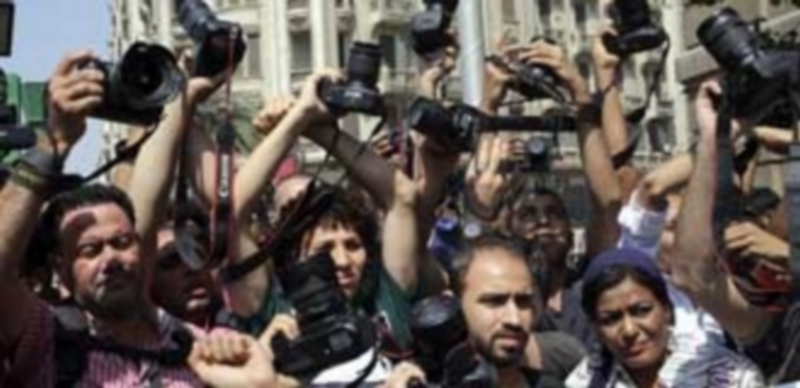 Cientos de fotoperiodistas alzan sus cámaras en señal de protesta durante una manifestación en El Cairo