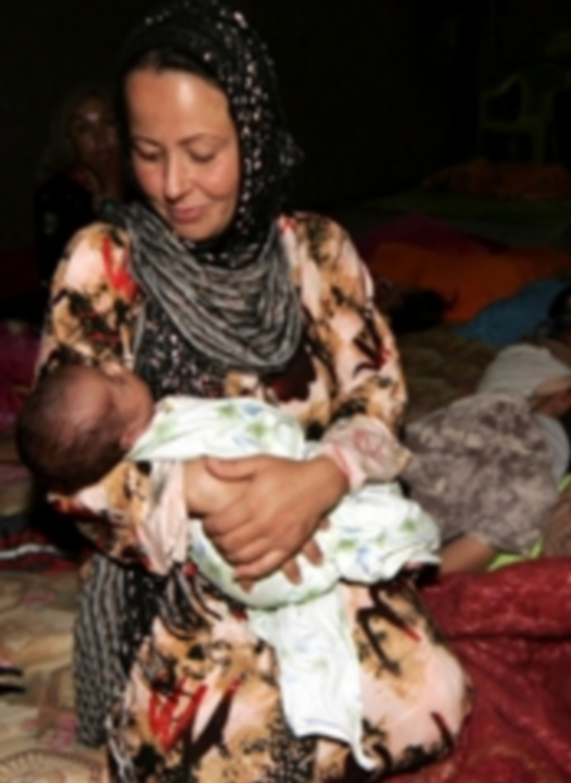 Una madre iraquí mira al bebé de pocos meses que tiene en sus brazos. / Efe