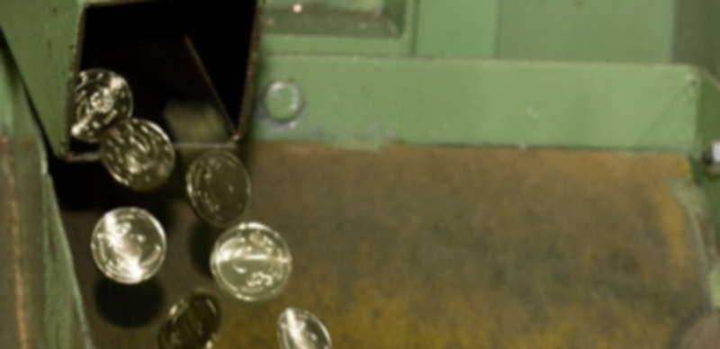 Una máquina en funcionamiento de la Fábrica de Moneda y Timbre expide monedas de 20 céntimos de euro. / EP