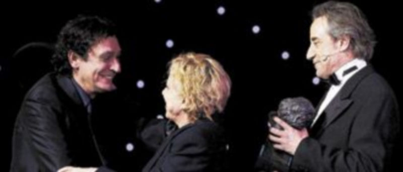 Agustí Villaronga (i) recibe de manos de los actores Rosa María Sardá y Juanjo Puigcorbé el galardón al mejor director por ‘Pa negre’. / Efe.