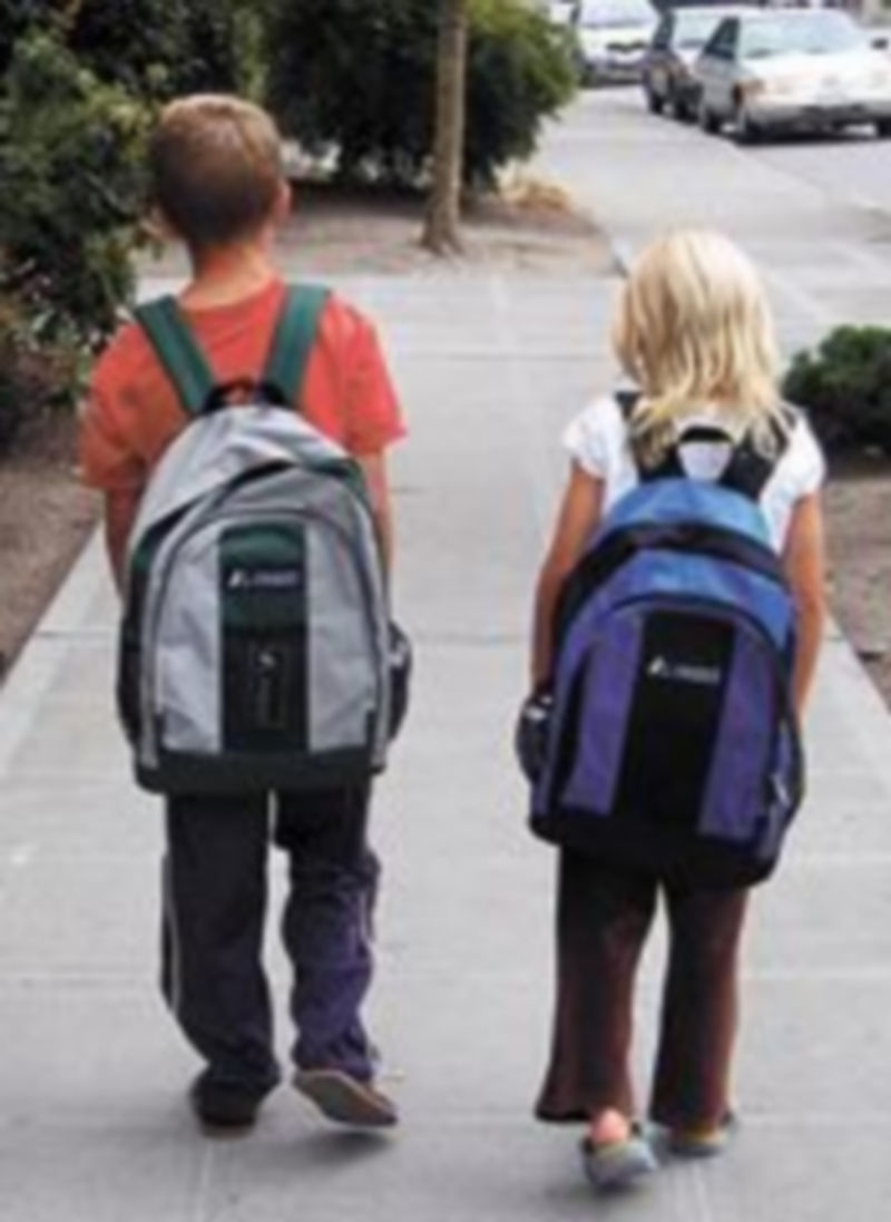 Dos niños caminan por una calle.