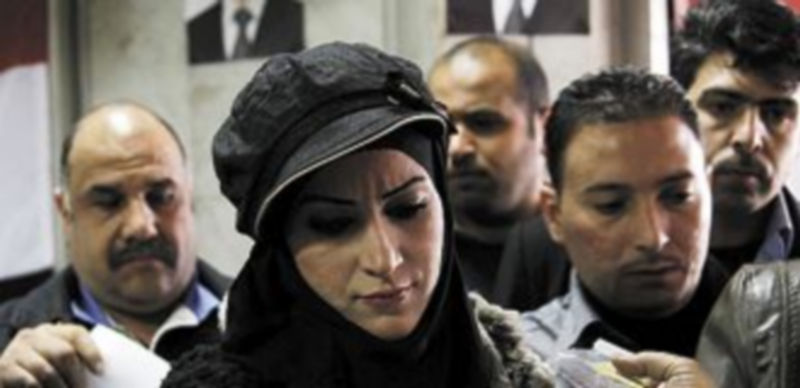 Una mujer deposita su voto en una urna. / Reuters