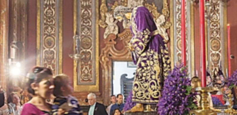 Una mujer y su hijo pasan ante la imagen del Padre Nuestro Jesús de la Pasión en Sevilla. / EFE