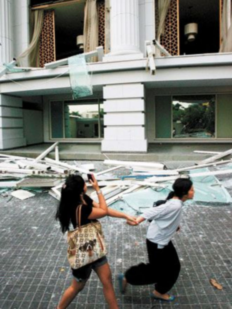Dos mujeres corren frente al hotel Ritz Carlton de Yakarta