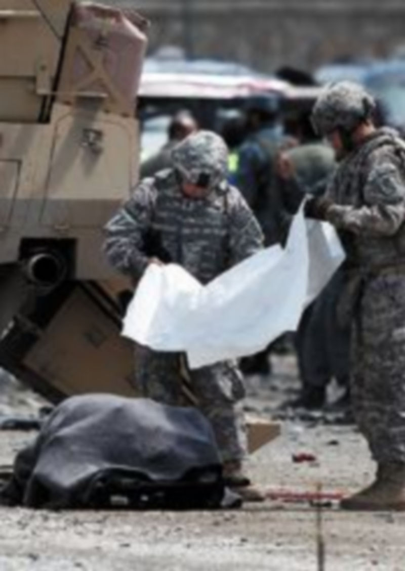 Soldados de EEUU cubren el cuerpo de una víctima del ataque. / Reuters