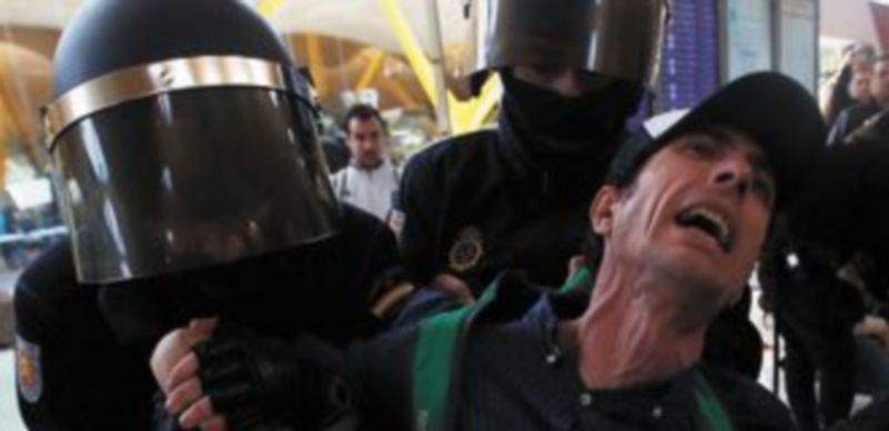 Varios agentes reducen a un trabajador que protestaba en la T-4 de Madrid-Barajas. / Reuters