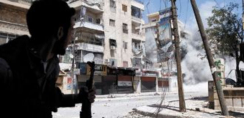Un rebelde sirio contempla un ataque de las tropas gubernamentales sobre la ciudad de Homs. / Reuters