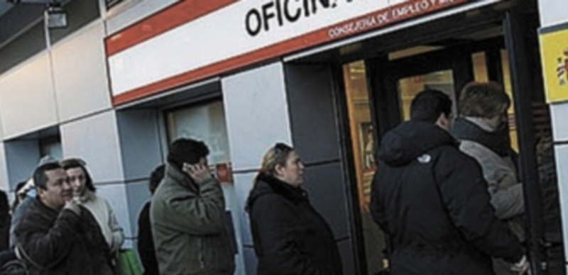 Un nutrido grupo de parados hace cola en una oficina de empleo en Madrid. / Efe