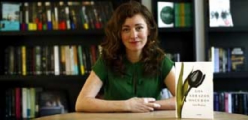 La escritora Julia Montejo posa junto a su novela ‘Los abrazos oscuros’. / E.P.