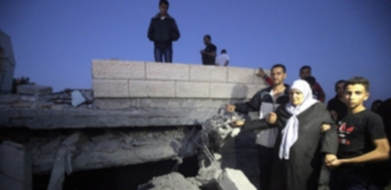 Una familia palestina vuelve a su hogar tras los bombradeos reanudados ayer tras romperse el alto el fuego. / Efe