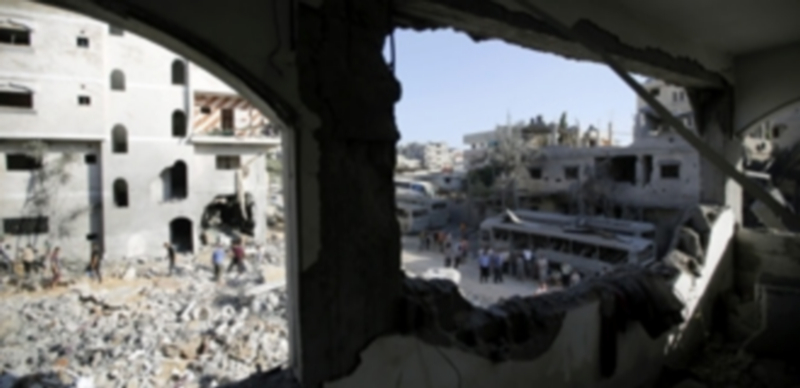 Un grupo de palestinos inspecciona las ruinas de la casa de la familia Al-Dalow después de un ataque aéreo israelí en la Franja de Gaza. / Efe