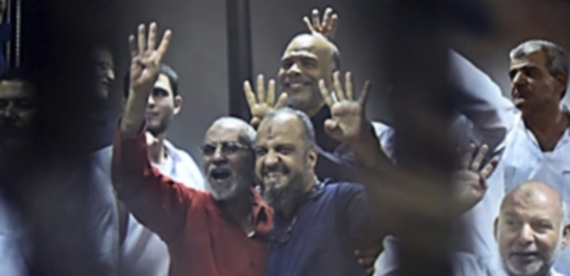 El expresidente egipcio (i) protesta en el juicio con el resto de acusados. / Efe