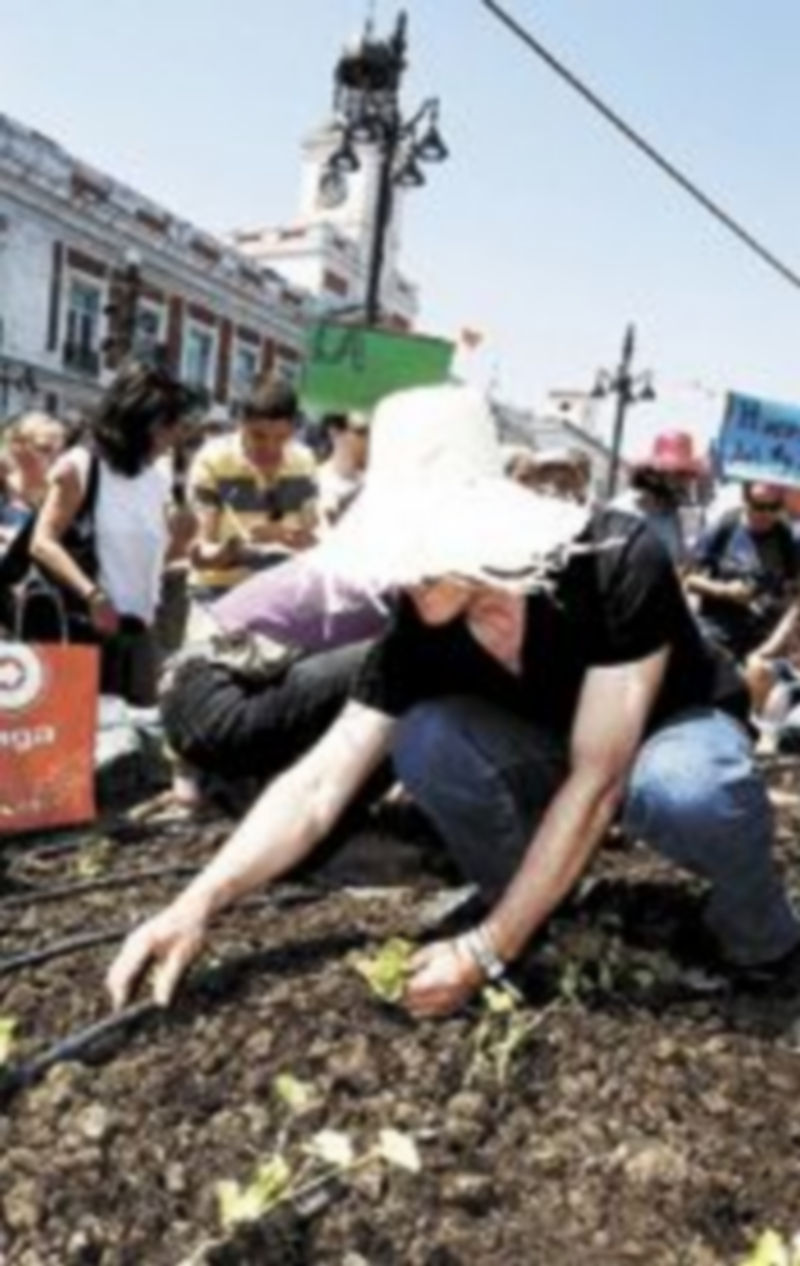 Un hombre trabaja en un simbólico huerto ecológico. / Efe